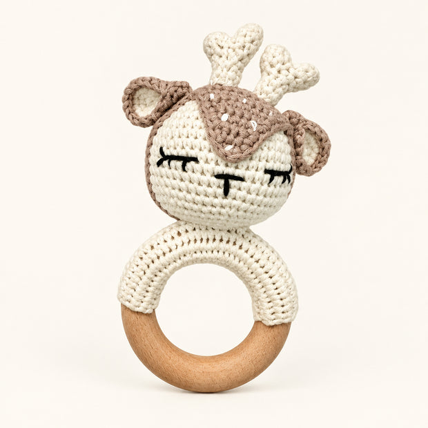 Crocheted bunny baby rattle in cream and taupe yarn with embroidered sleepy eyes attached to wooden teething ring