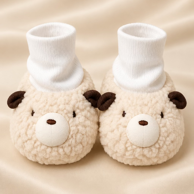 Pair of plush animal slippers with face designs on a light surface.