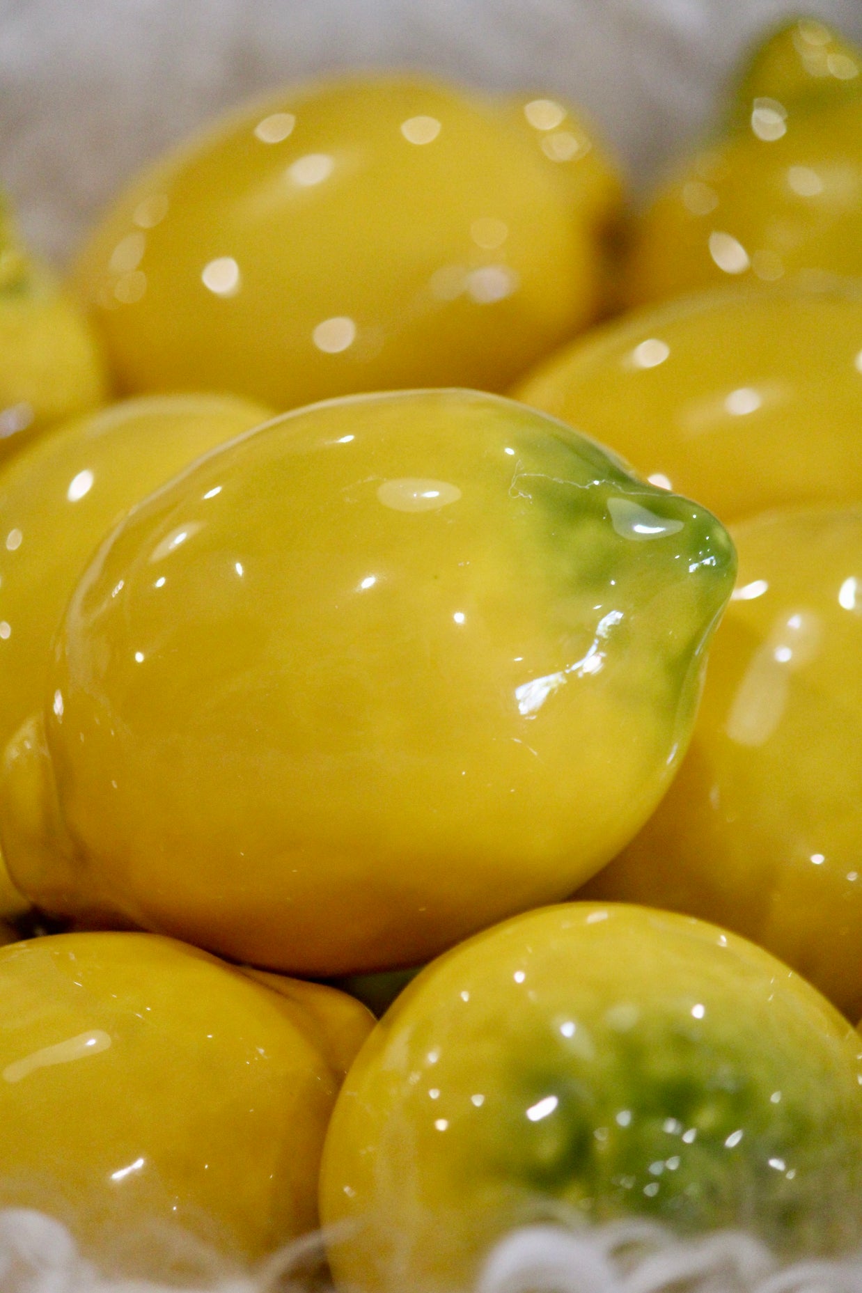 Bright yellow bell peppers with glossy smooth skin and green stems clustered together in close-up macro view