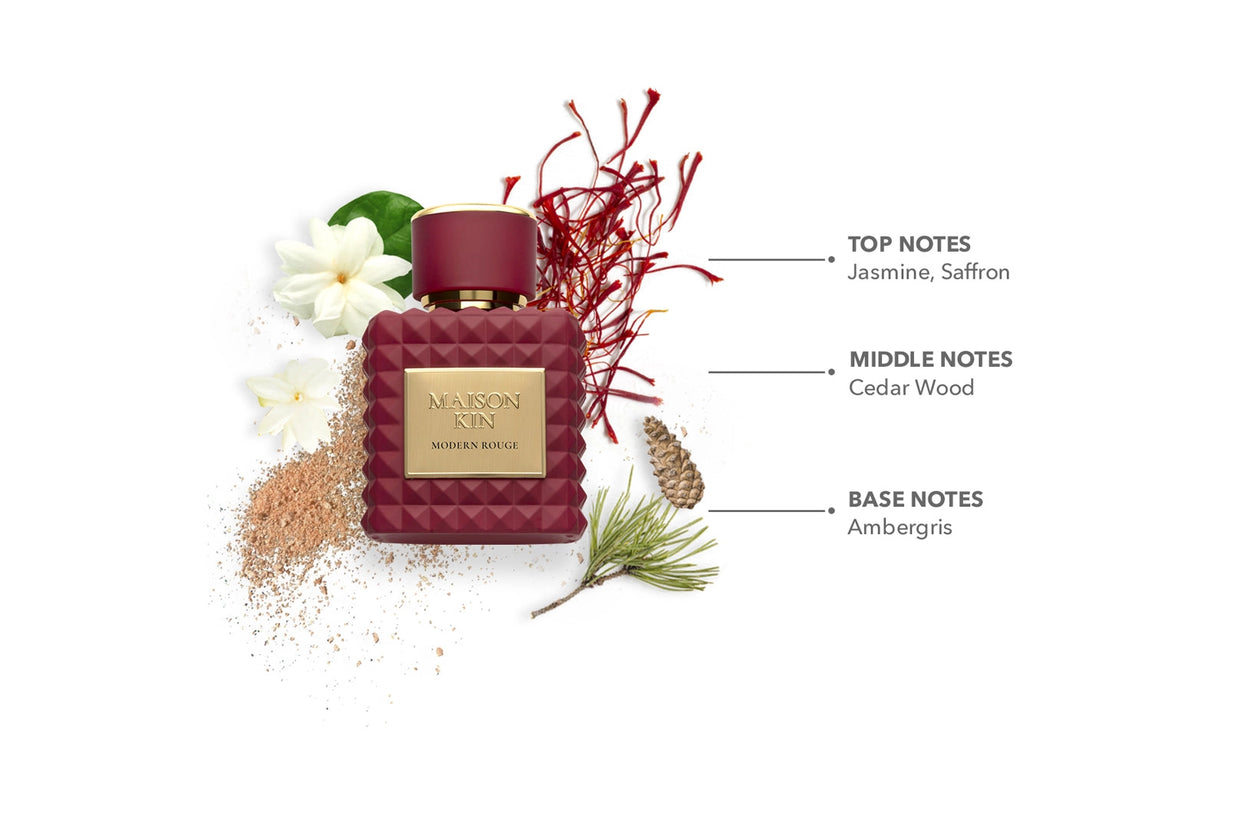 Deep red quilted glass perfume bottle with gold label surrounded by jasmine flowers, saffron threads, and pine sprigs