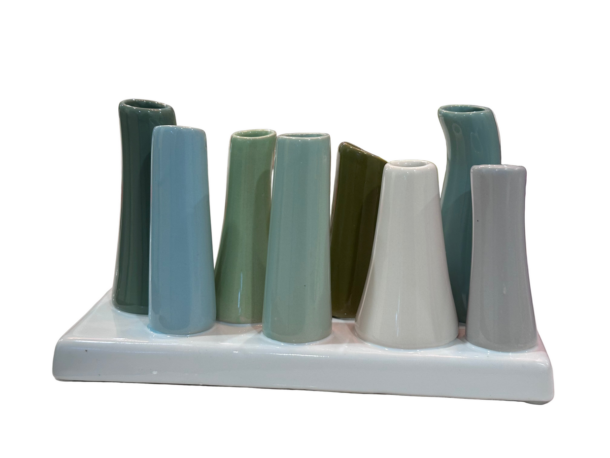Ceramic multi-vase holder with nine tapered tubular openings in teal, sage, olive, and gray glazes on white base
