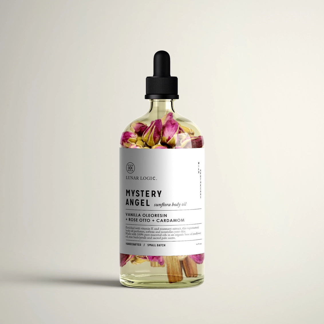 Glass dropper bottle with dried pink rose petals and cinnamon sticks in golden oil, white label reading Mystery Angel
