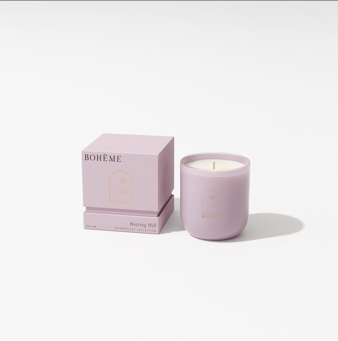 Blush pink ceramic candle in cylindrical vessel with cream wax beside matching cube packaging labeled Bohème Notting Hill