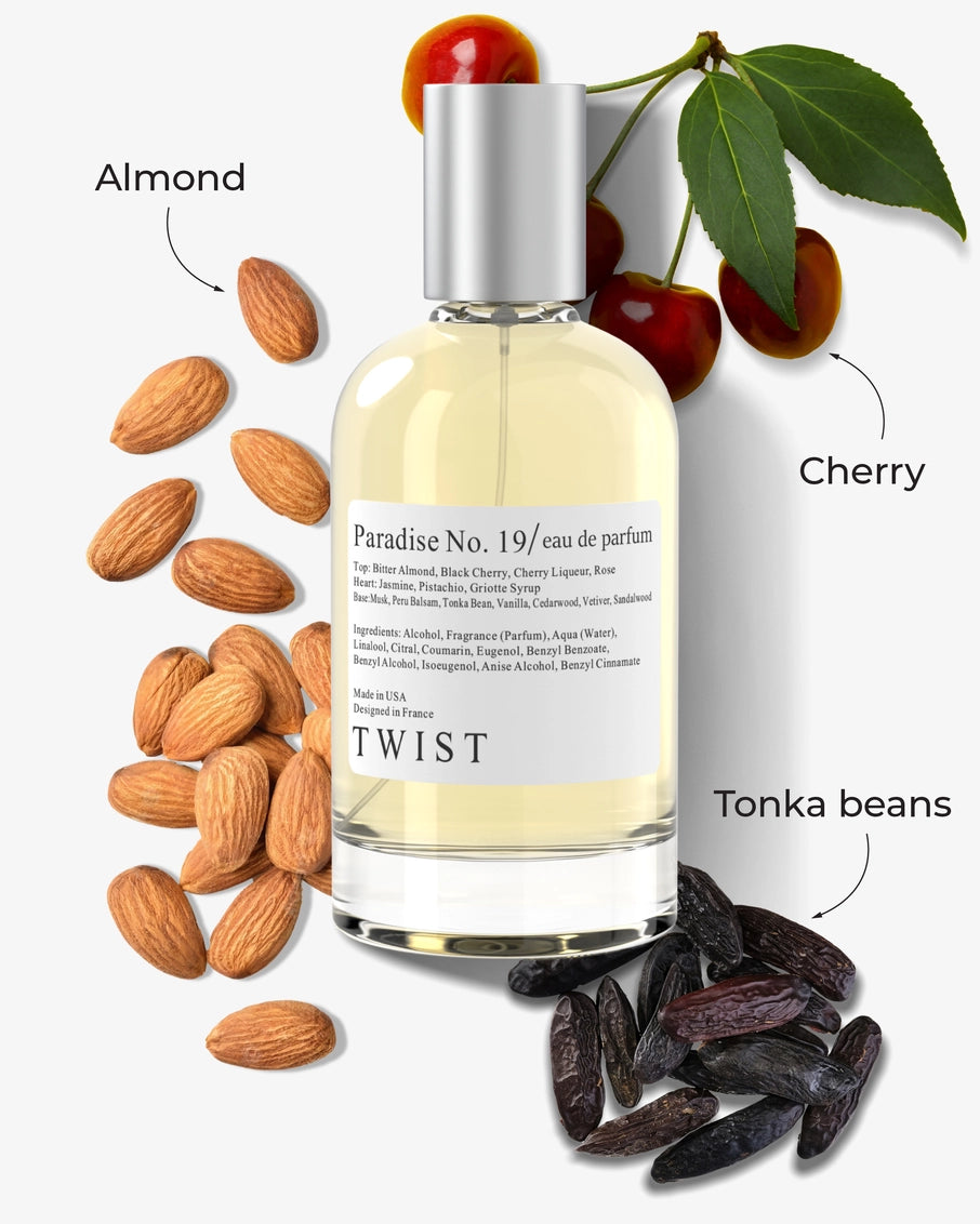 Clear glass perfume bottle with silver cap surrounded by almonds, dark red cherries with stems, and dried tonka beans