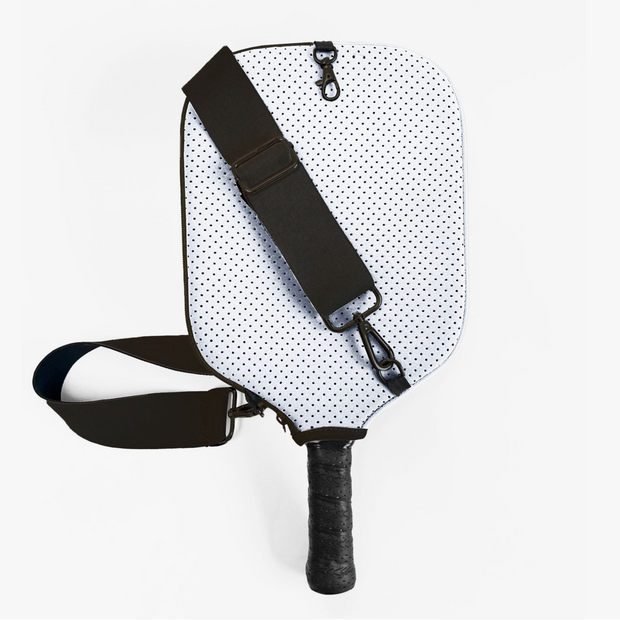 White pickleball paddle cover with black polka dots, black adjustable shoulder strap and textured grip handle