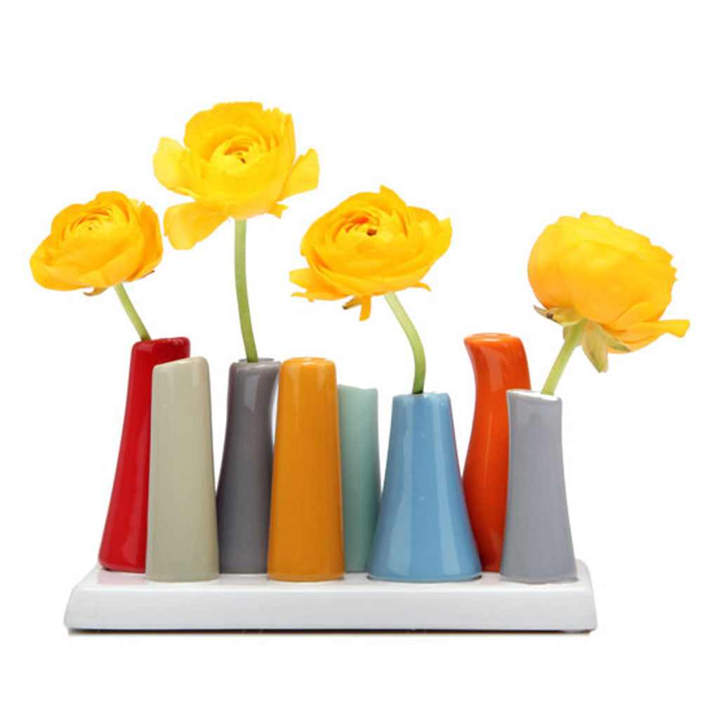 Multi-tube bud vase set with eight conical tubes in red, cream, gray, orange, mint, and blue glazed ceramic on white base