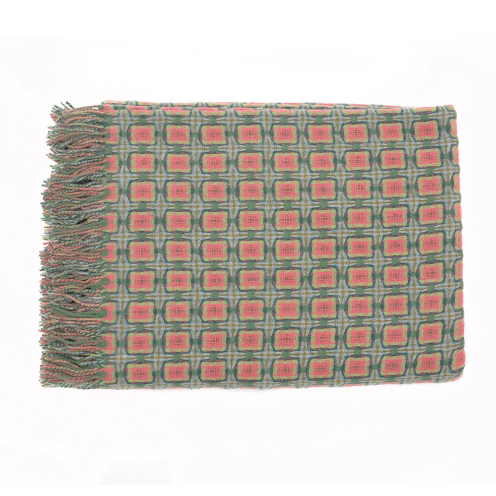 Woven throw blanket with coral pink and sage green geometric medallion pattern and twisted fringe on left edge