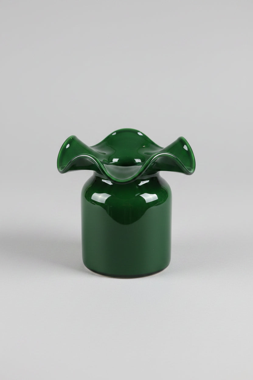 Emerald green glass vase with ruffled wavy rim on cylindrical base with glossy finish and light reflections
