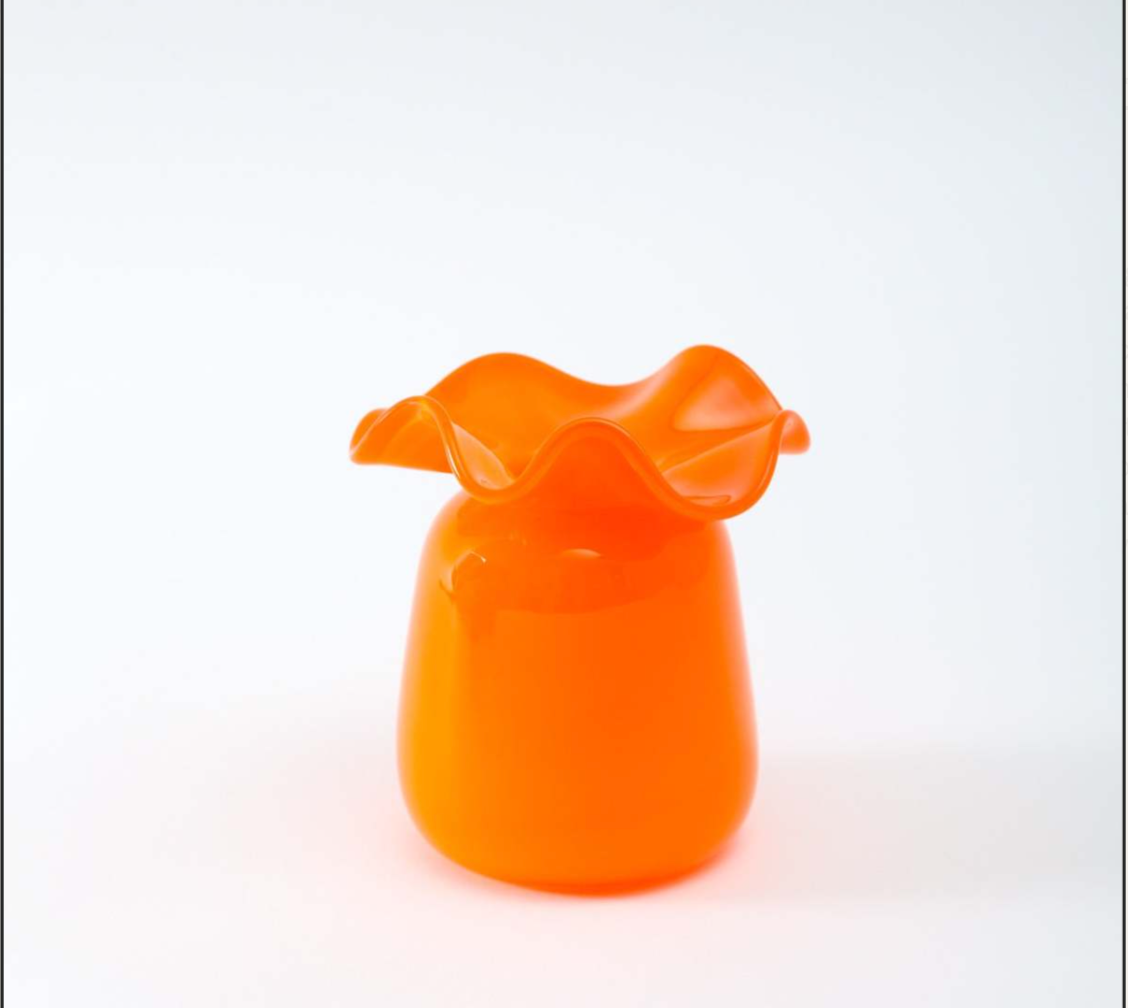 Bright orange glass vase with ruffled wavy rim and smooth bulbous body on white background
