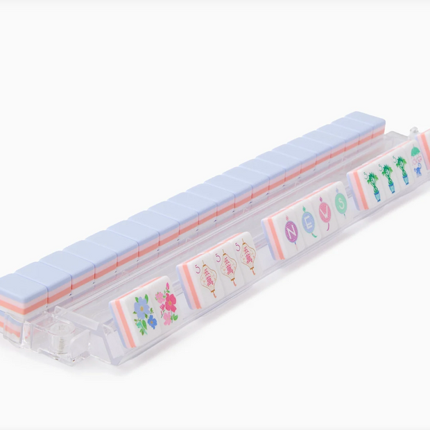Clear plastic pill organizer with pale blue lid displaying colorful floral and cactus illustrations on compartments