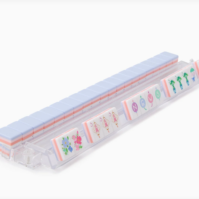 Clear plastic pill organizer with pale blue lid displaying colorful floral and cactus illustrations on compartments