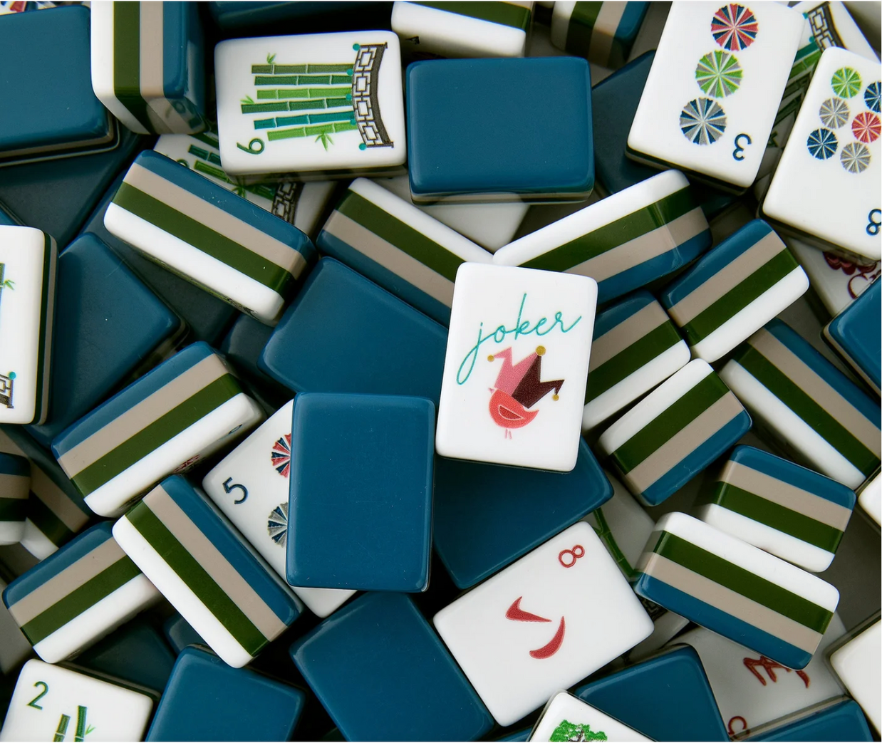 Mid-century modern mahjong set with teal blue backs, striped tiles in green and blue, and retro illustrated face tiles