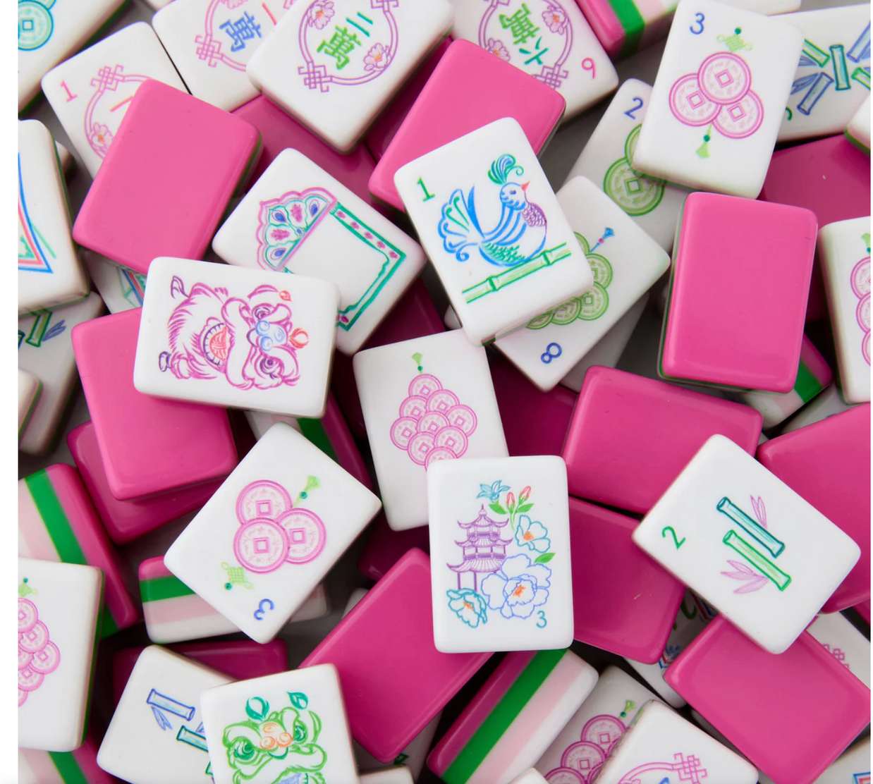 Mahjong tiles scattered showing white pieces with colorful traditional symbols and solid pink tiles in vibrant fuchsia shade