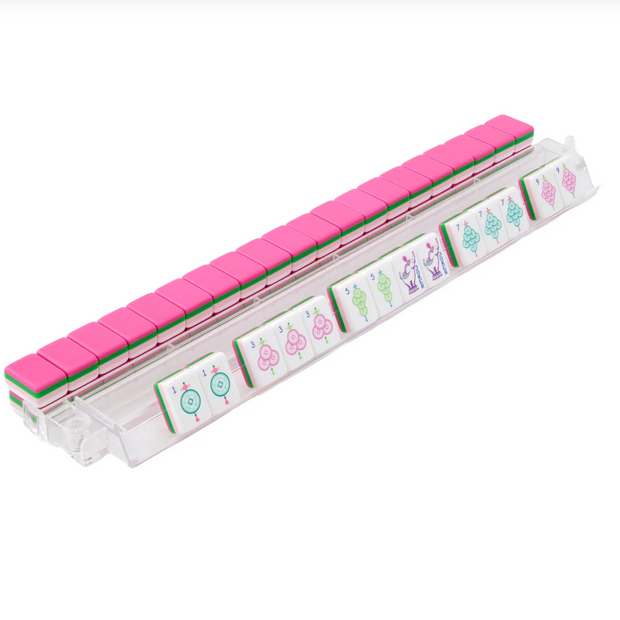 Clear acrylic mahjong tile rack with pink lid and green trim displaying colorful numbered tiles with circle and bamboo symbols