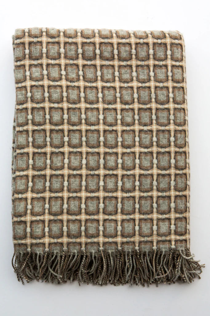 Woven wool throw blanket with geometric grid pattern in sage green, taupe, and cream with knotted fringe trim
