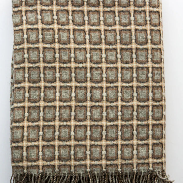 Woven wool throw blanket with geometric grid pattern in sage green, taupe, and cream with knotted fringe trim