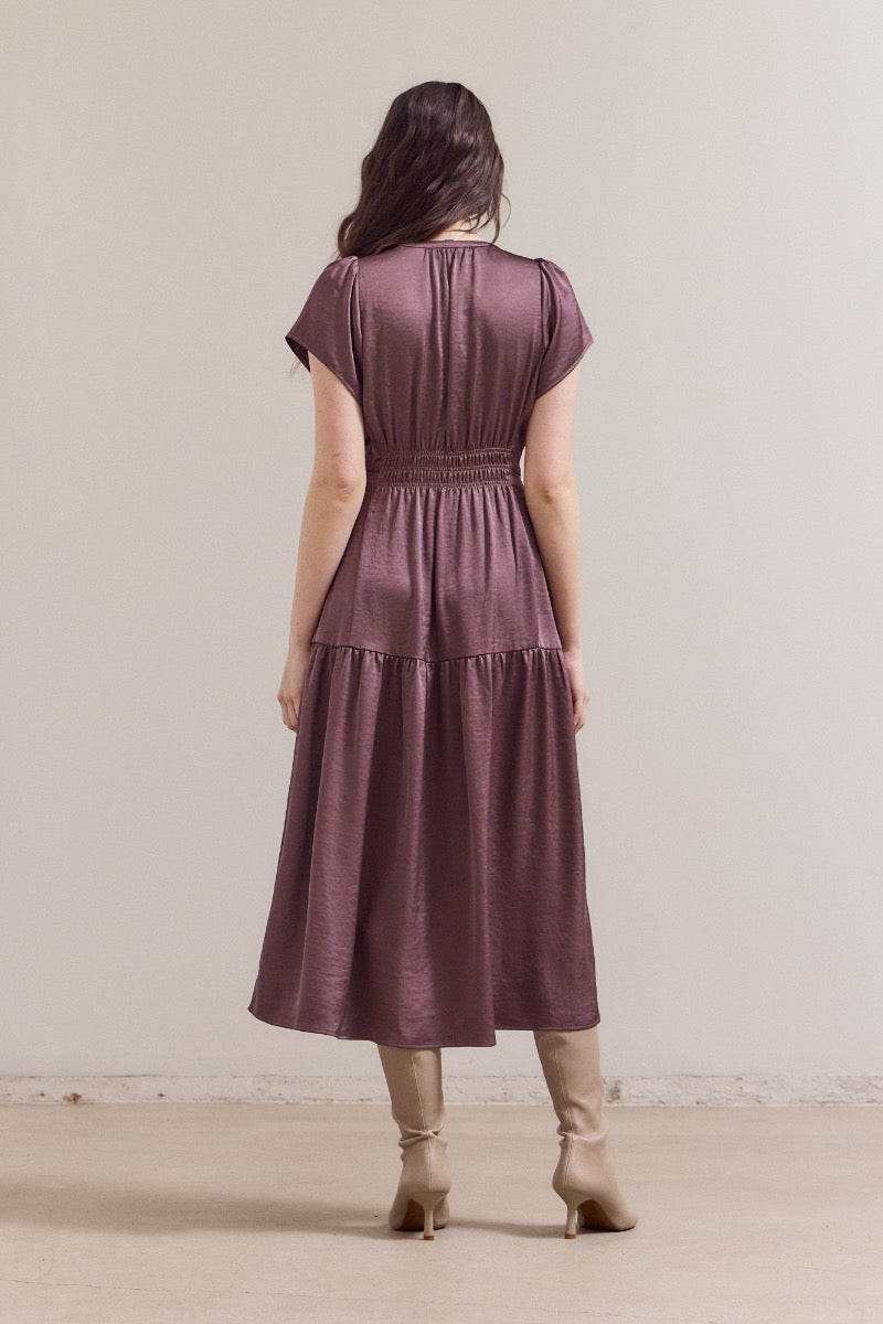 Mauve satin midi dress with gathered elastic waist, tiered skirt, short sleeves, and subtle sheen, back view