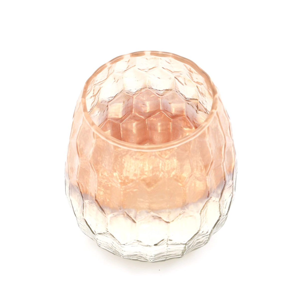 Peach-tinted glass votive candle holder with honeycomb faceted texture and dome-shaped lid on white background