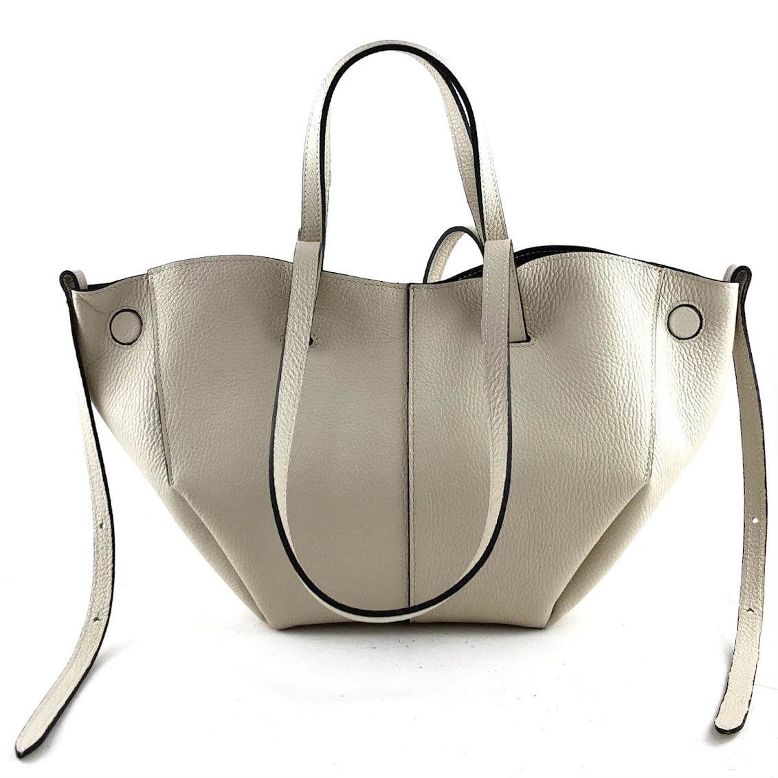 Cream pebbled leather tote bag with black contrast piping, dual handles, detachable shoulder strap, and silver grommet details