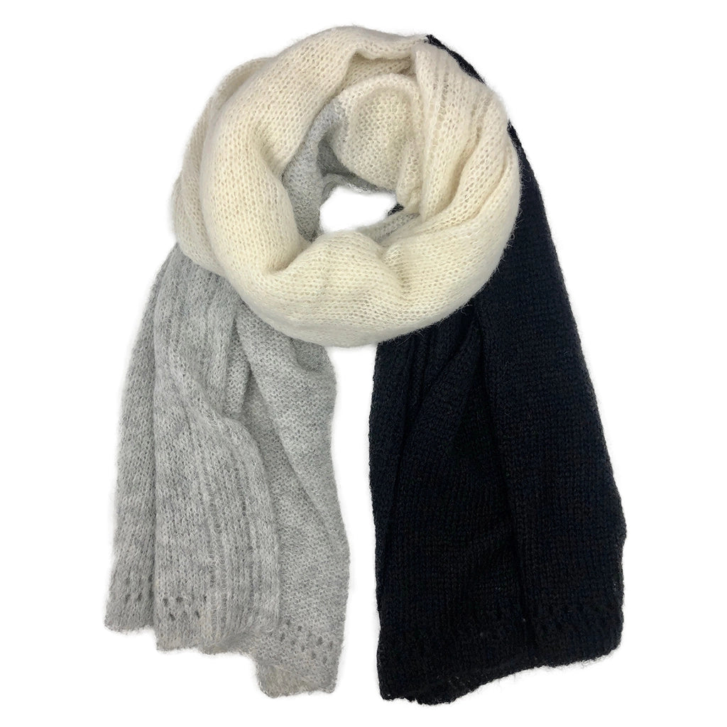 Tri-color knit scarf in cream, light gray, and navy blocks with cable knit texture, draped to show soft alpaca fabric