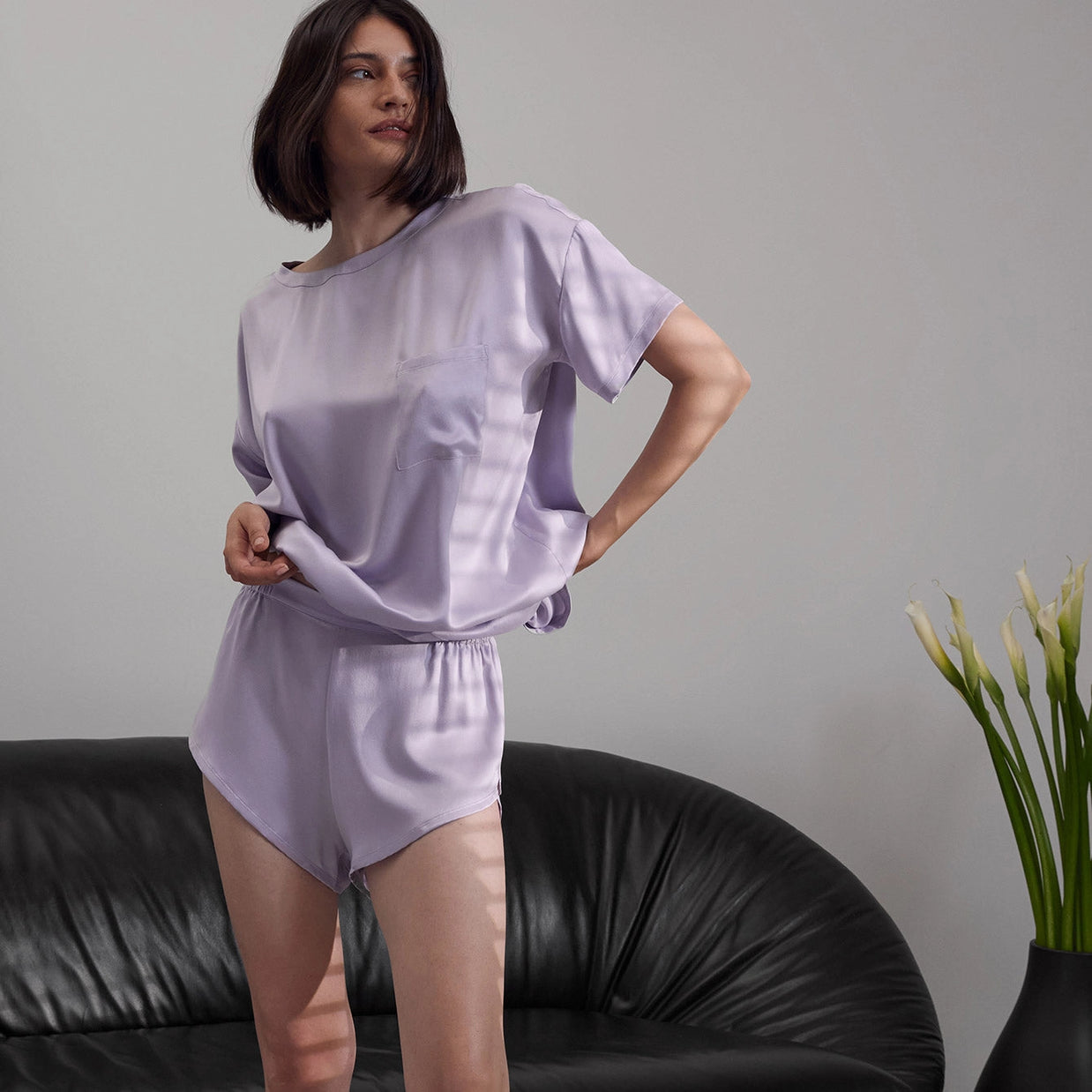 Lavender silk short-sleeve pajama set with relaxed-fit top featuring chest pocket and matching elastic-waist shorts