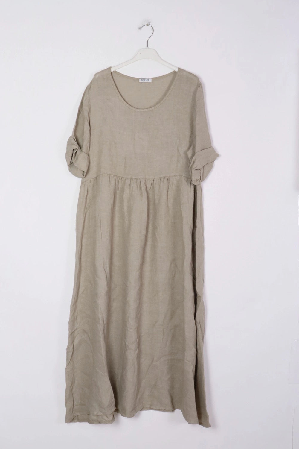 Natural beige linen maxi dress with gathered waist, rolled three-quarter sleeves, and relaxed A-line silhouette on white hanger