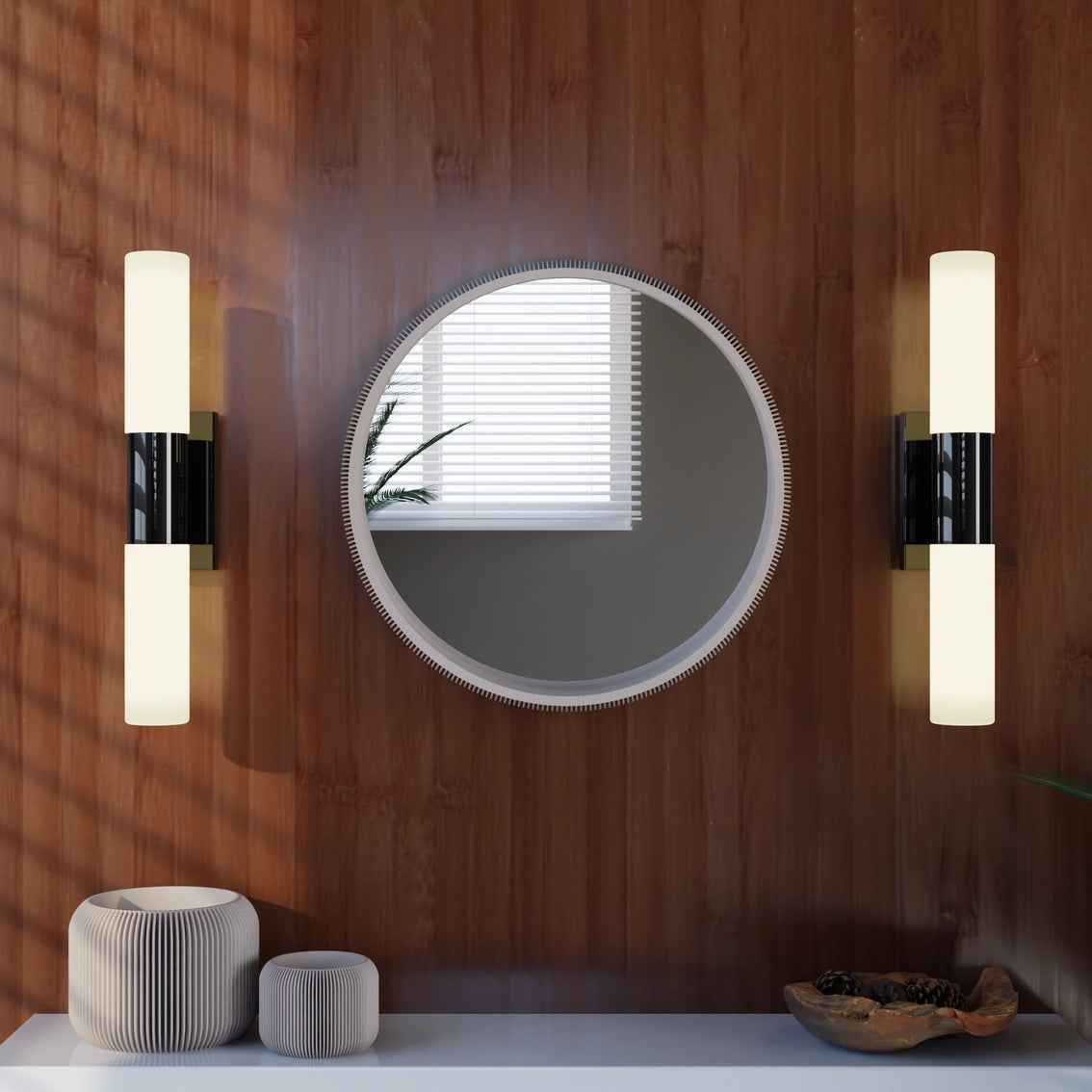 Round mirror with beaded copper frame flanked by modern cylindrical sconces with white glass shades on warm wood wall