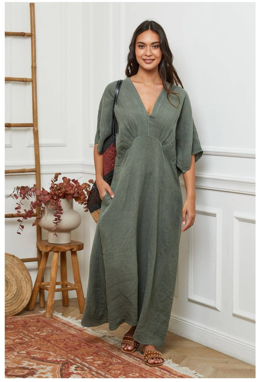 Sage green linen jumpsuit with kimono sleeves, deep V-neck, and wide-leg pants styled with woven crossbody bag