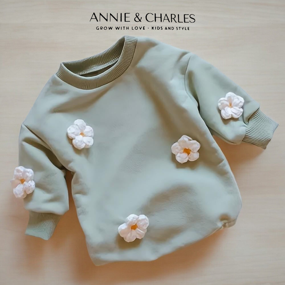 Sage green baby sweatshirt with white 3D flower appliques and ribbed cuffs on cream background