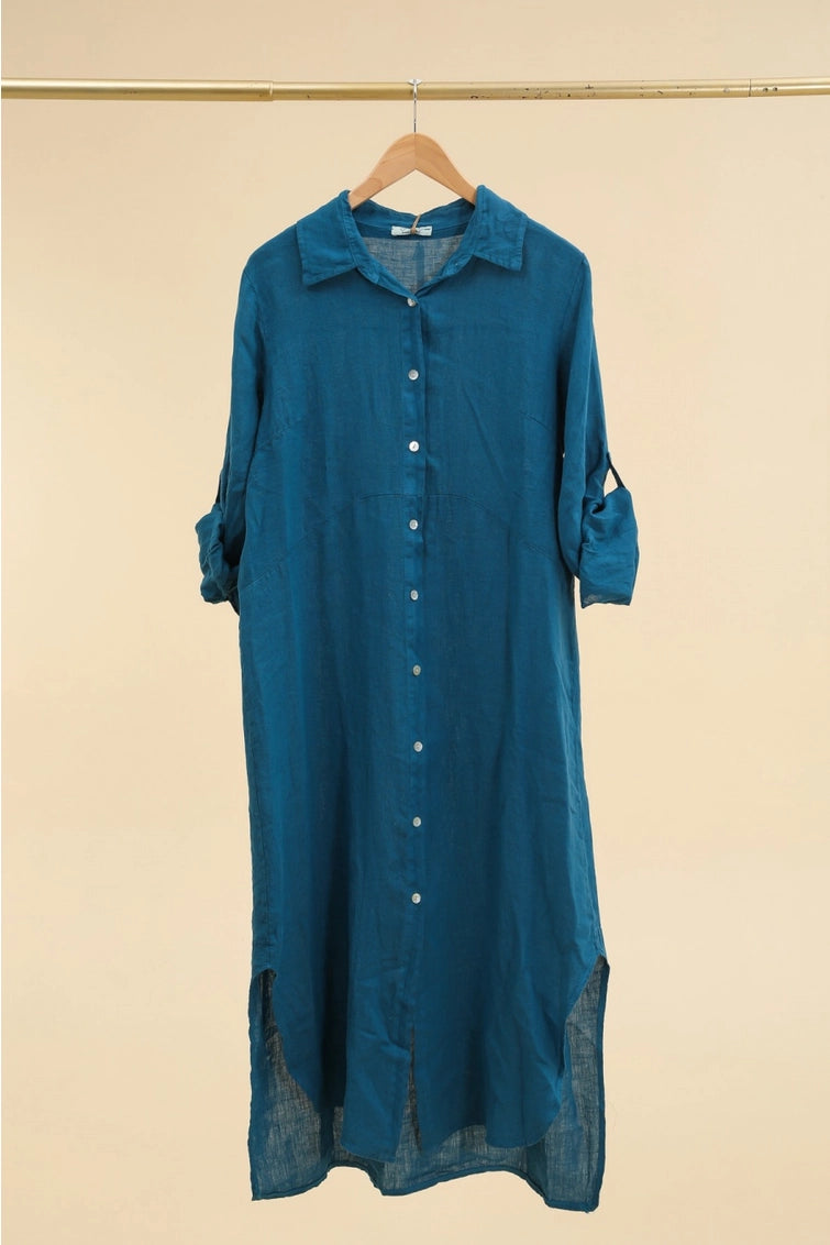 Teal linen shirt dress with white button front, rolled tab sleeves, chest pocket, and curved high-low hem on wooden hanger