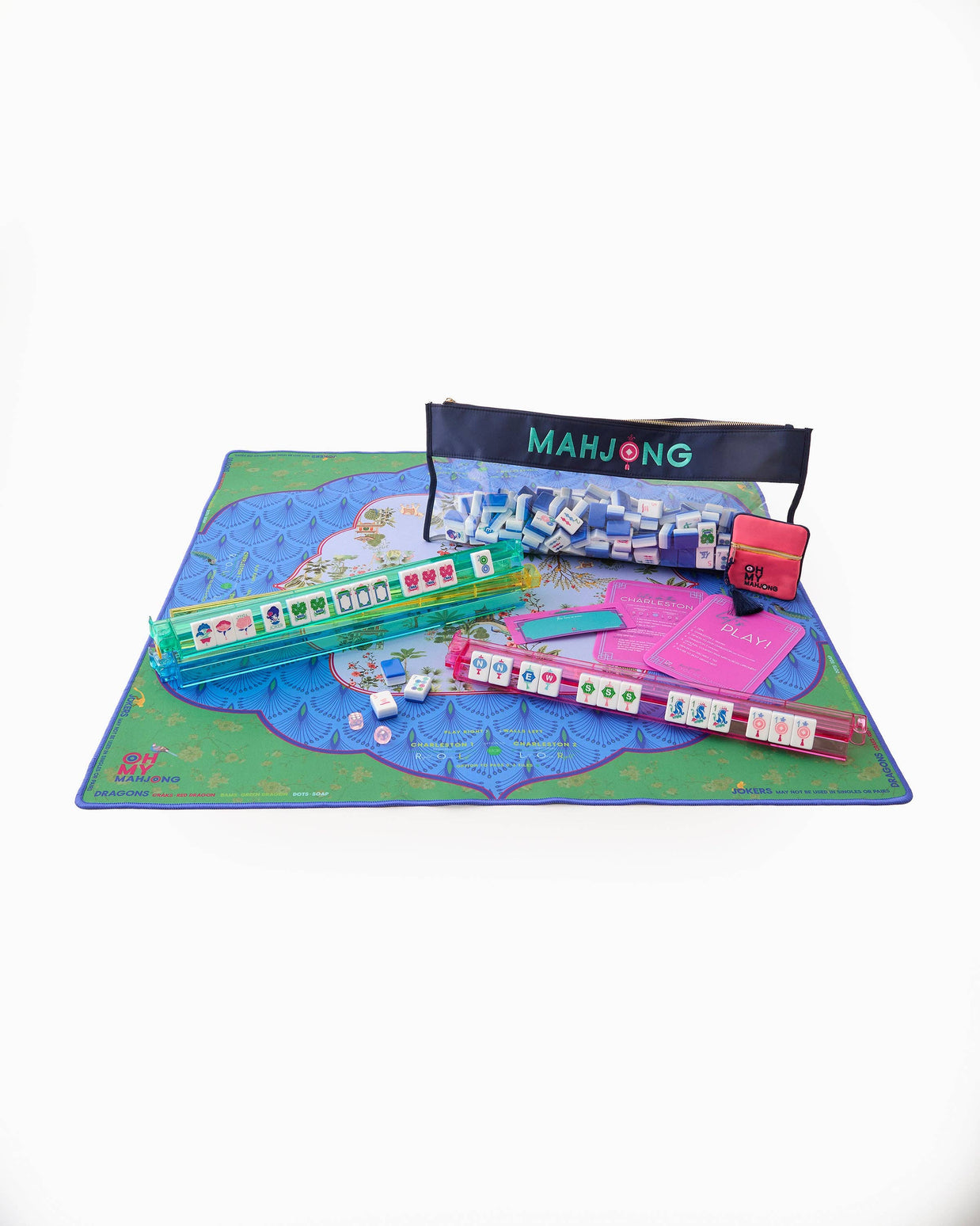 Complete mahjong game set with illustrated blue and green playmat, white tiles, teal racks, pink instruction cards, and navy pouch