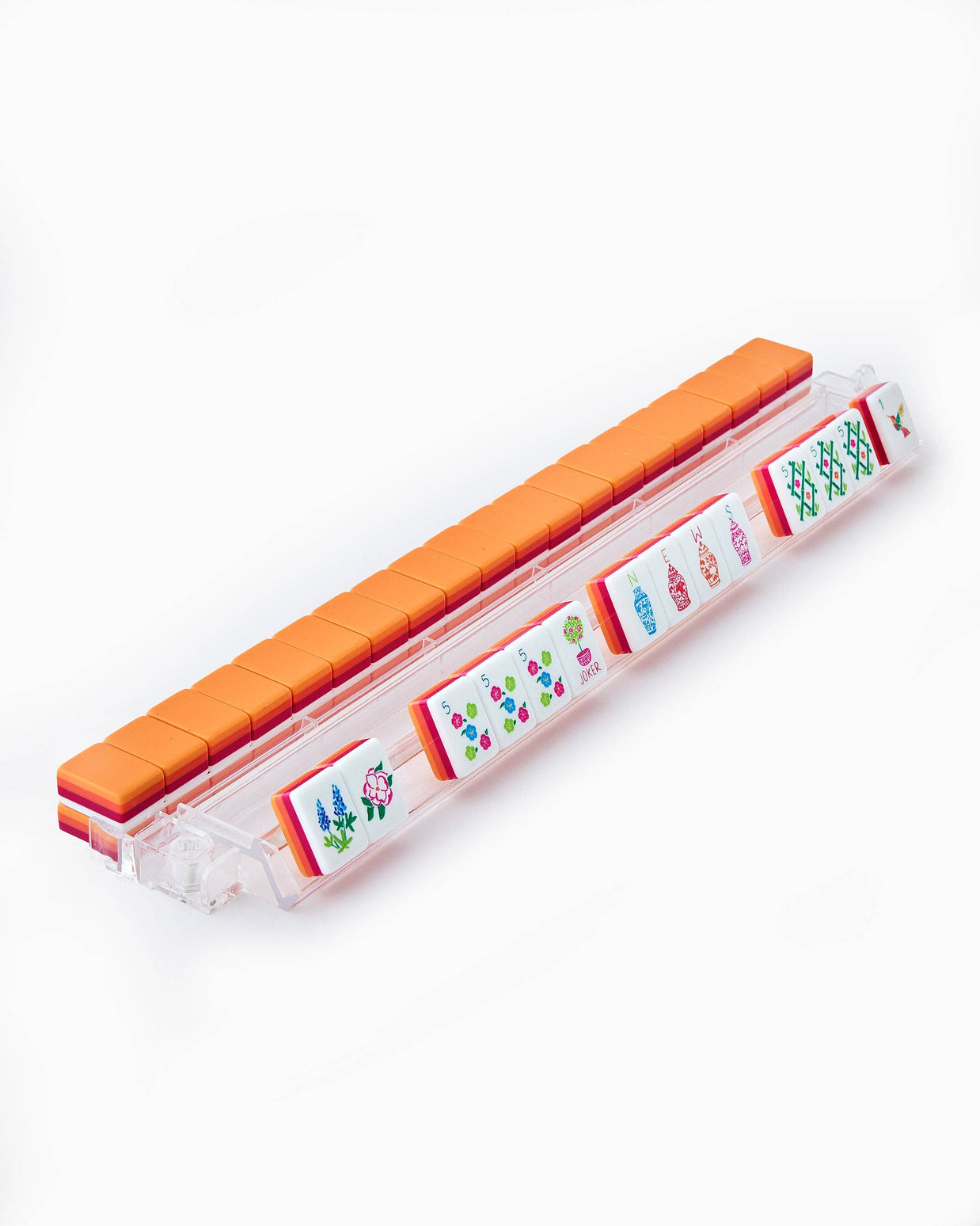 Miniature mahjong game set with orange plastic tiles and clear storage case displaying colorful floral character tiles