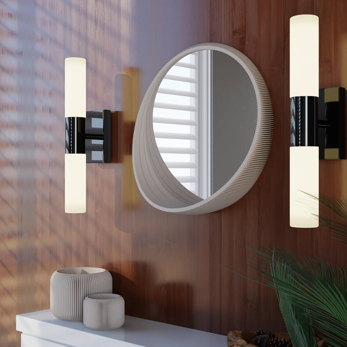 Round wall mirror with ribbed taupe frame flanked by modern black and white cylindrical sconce lights on wood panel wall