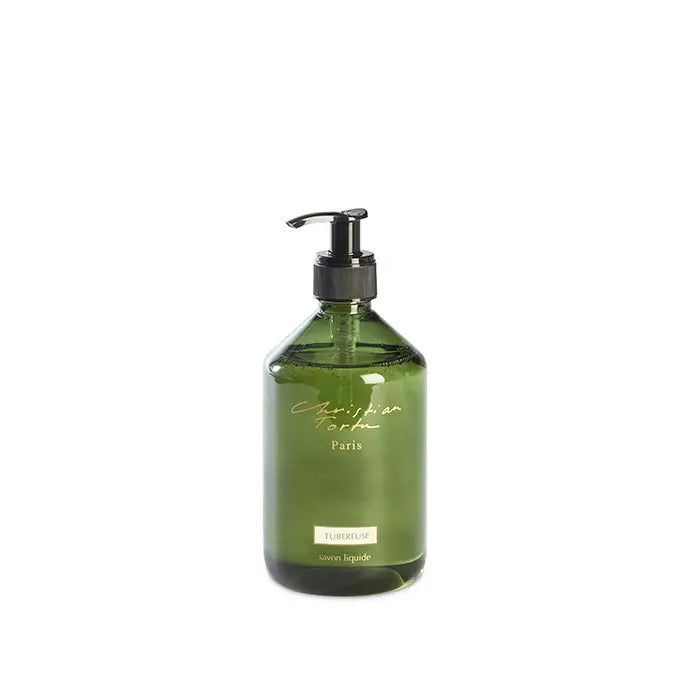 Olive green glass bottle with black pump dispenser, gold script branding, labeled tuberose liquid soap in rounded apothecary style
