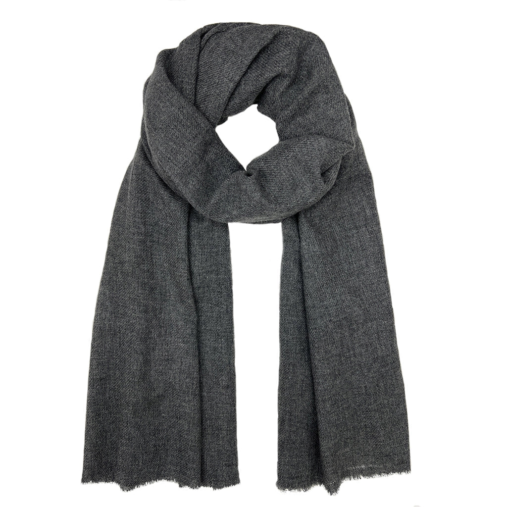 Charcoal gray knit scarf with textured weave and raw frayed edges draped loosely against white background