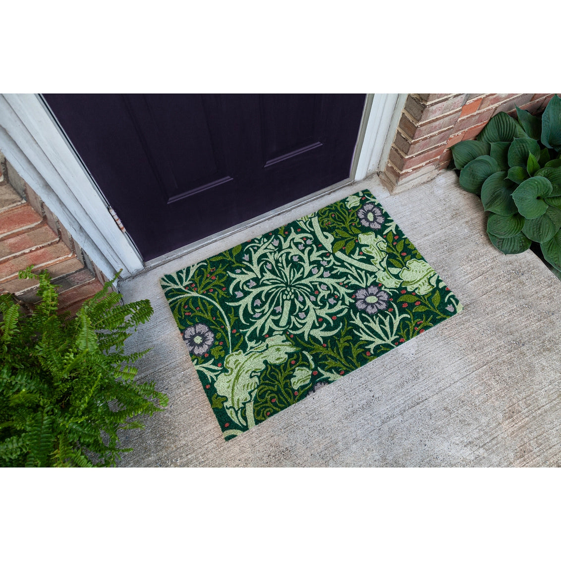 Doormat with ornate William Morris-style botanical pattern in dark green, sage, and lavender florals on front porch