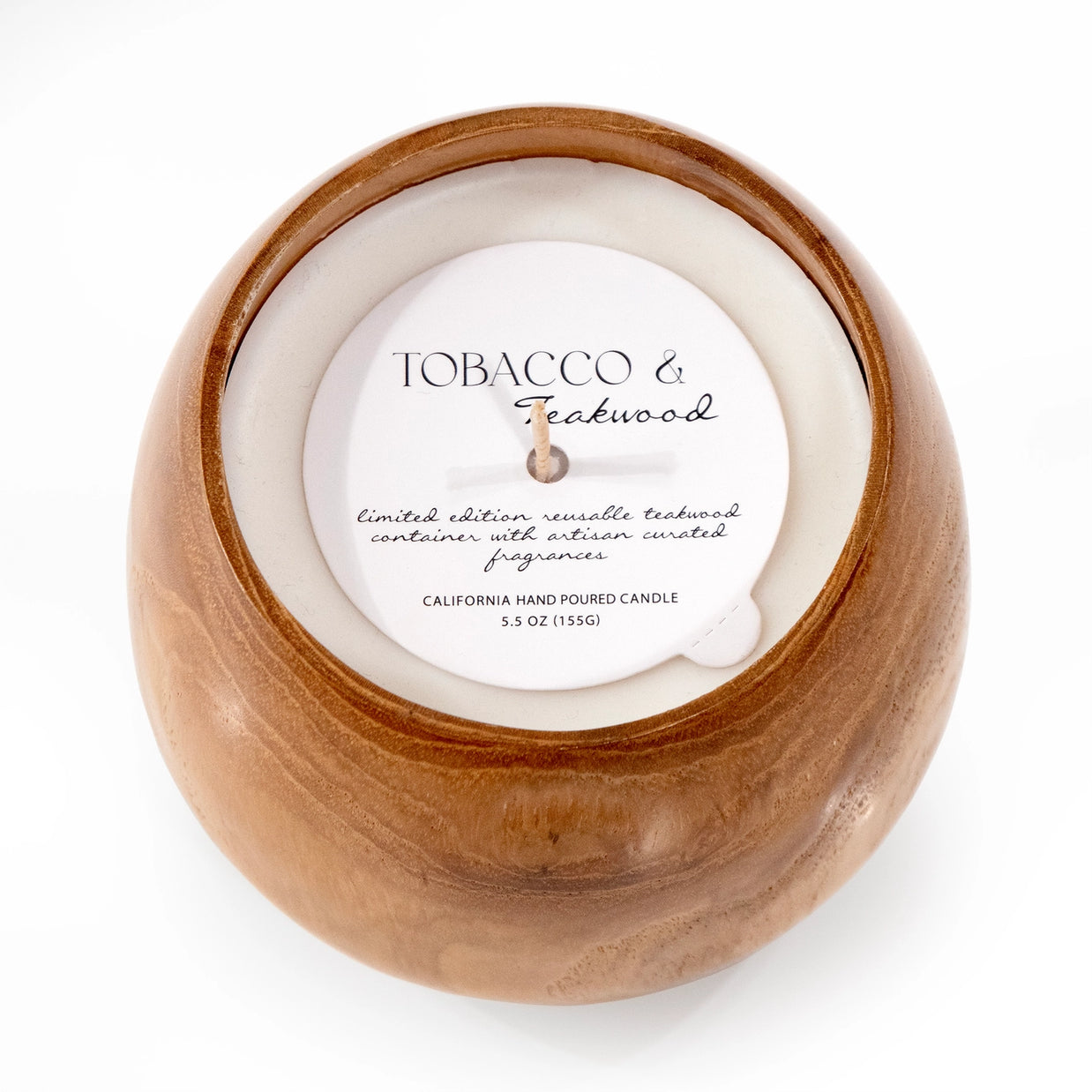 Round natural teak wood bowl candle with cream wax, labeled Tobacco & Teakwood in brown tones with wood grain detail