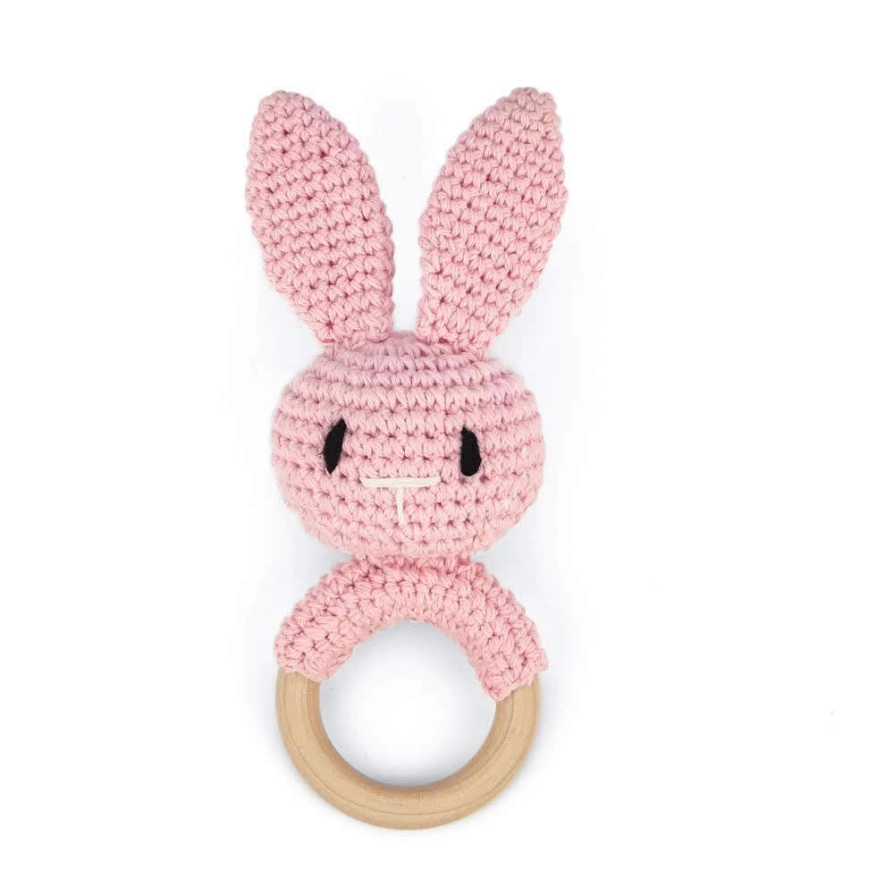 Crocheted pink bunny baby teether with wooden ring base, upright ears, black embroidered eyes and white stitched smile