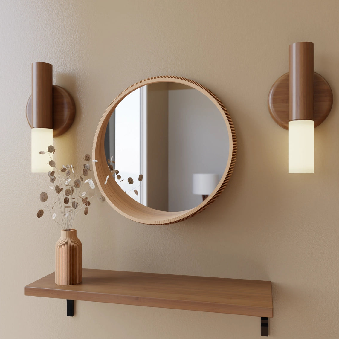 Round wood-framed mirror with matching cylindrical wall sconces and floating shelf displaying ribbed vase with dried eucalyptus