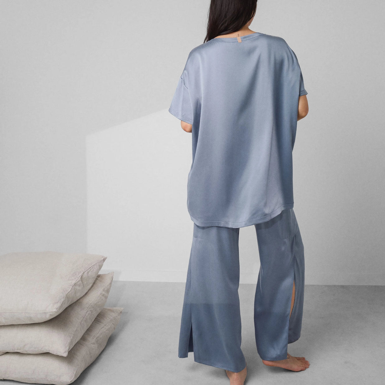 Dusty blue silk satin pajama set with oversized short-sleeve top and wide-leg pants shown from back on model