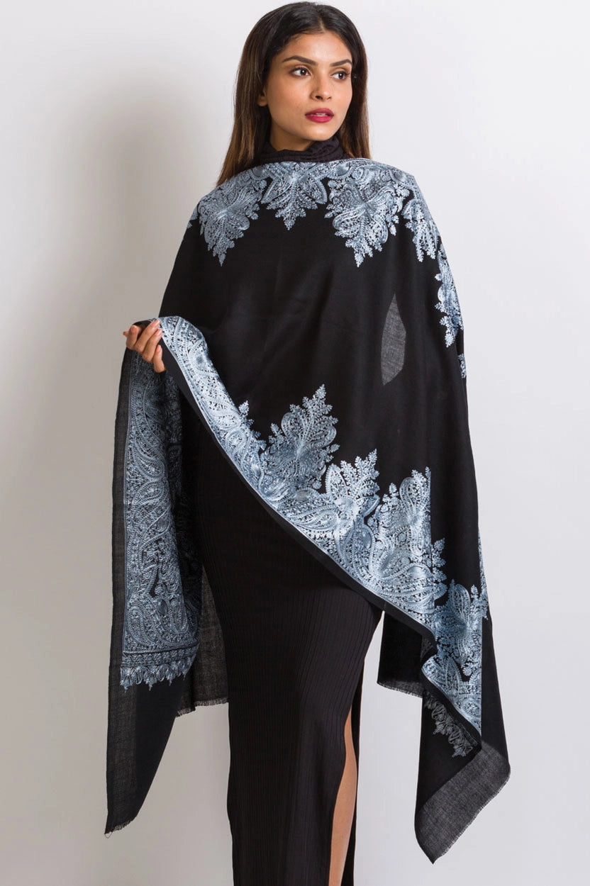 Black wool shawl with ornate silver-blue paisley embroidered border detailing along edges and fringe trim