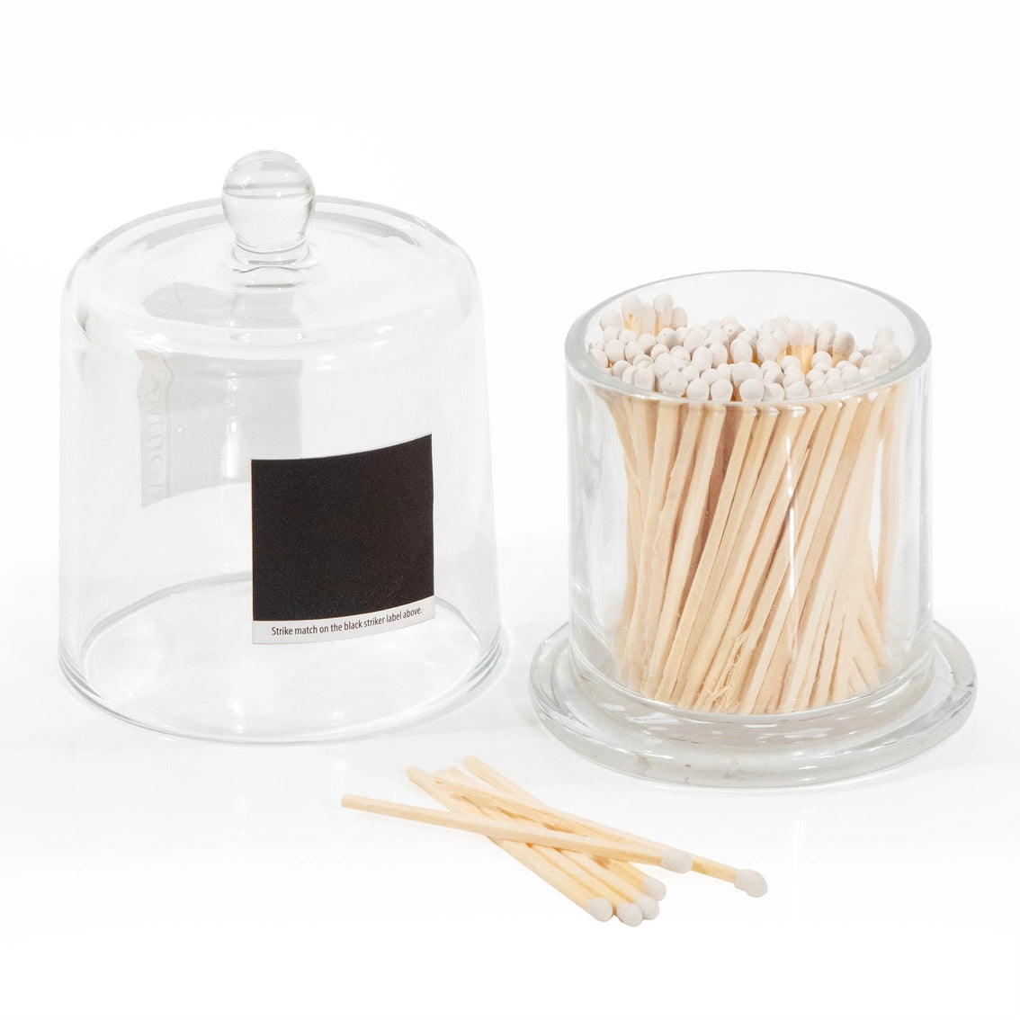 Clear glass apothecary jar with dome lid and striker pad, filled with natural wood matchsticks with white tips