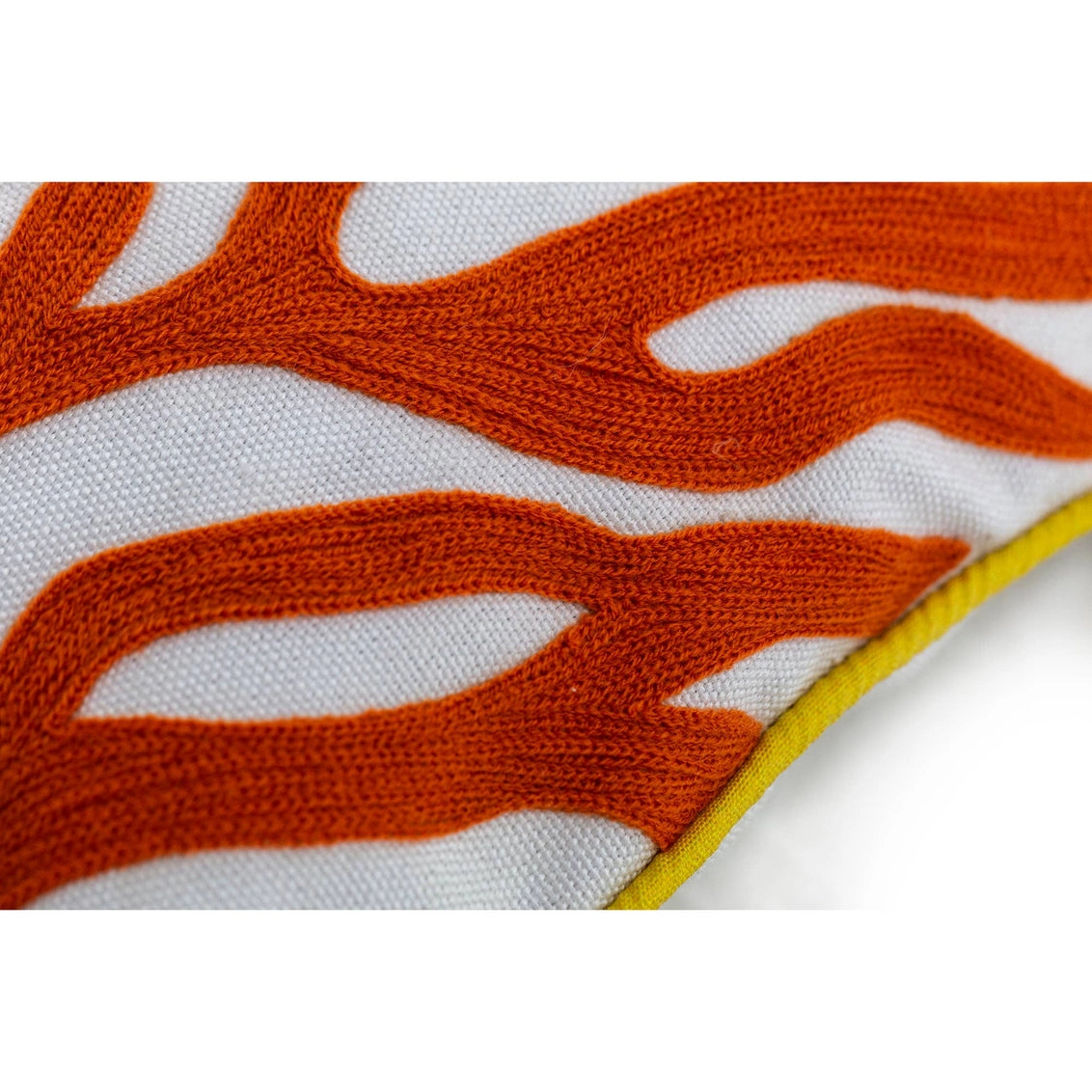 Embroidered textile with burnt orange wavy branch pattern on white canvas with yellow piping edge detail