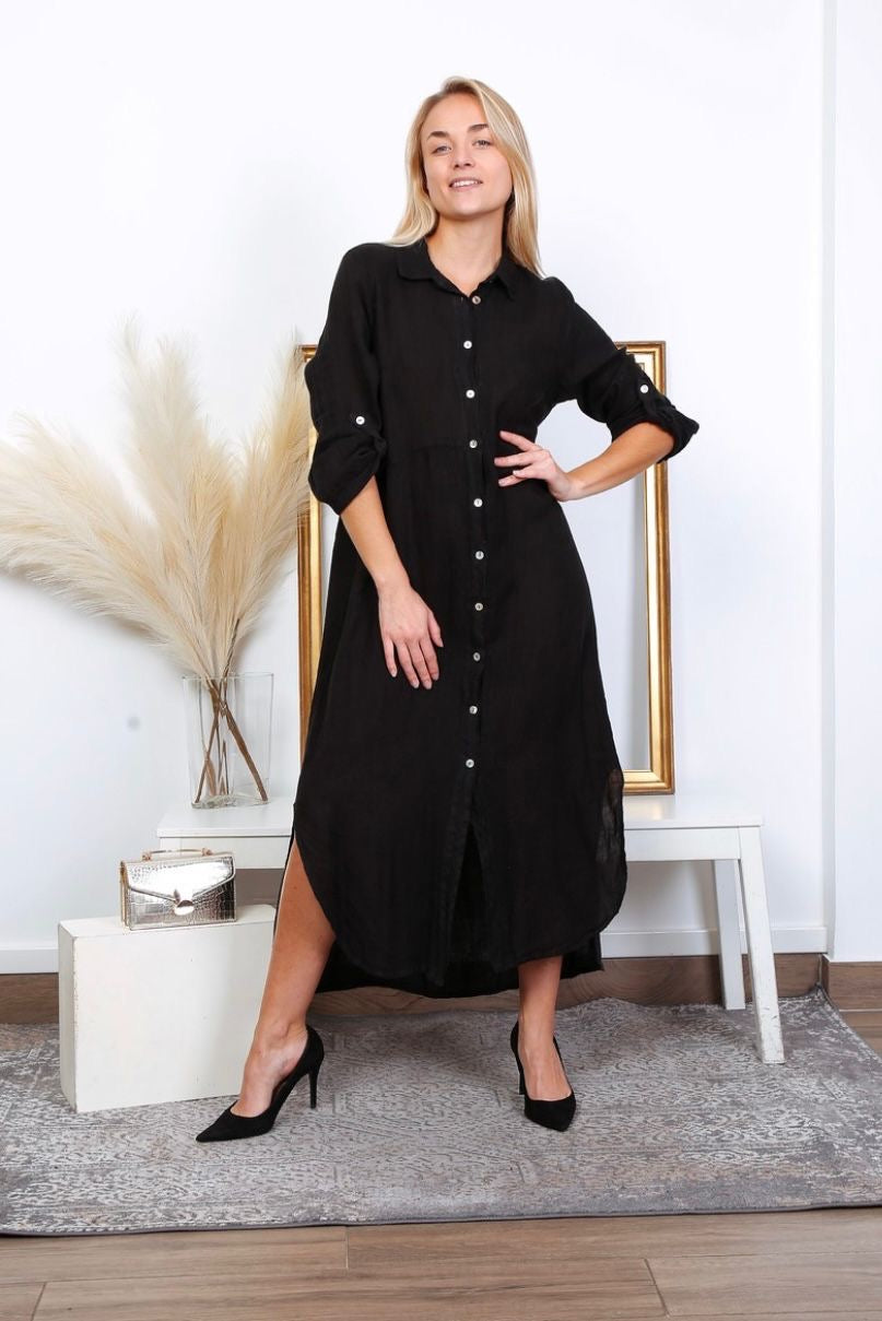 Black linen shirt dress with white button front closure, rolled three-quarter sleeves, and midi-length hemline