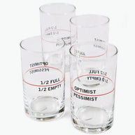 Clear glass tumblers with black text and red lines showing optimist/pessimist and half full/half empty measurements