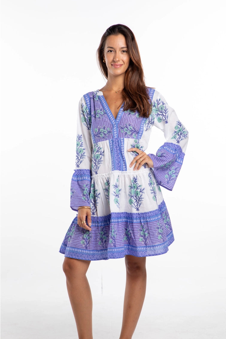 Tiered tunic dress in white with purple and green botanical print, featuring bell sleeves and V-neckline with button detail
