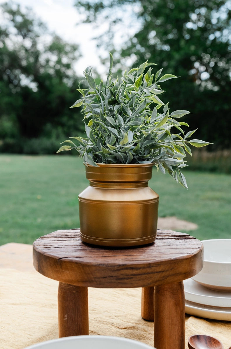 Artificial sage plant with silvery green leaves in bronze and cream ceramic planter on wooden pedestal stand outdoors