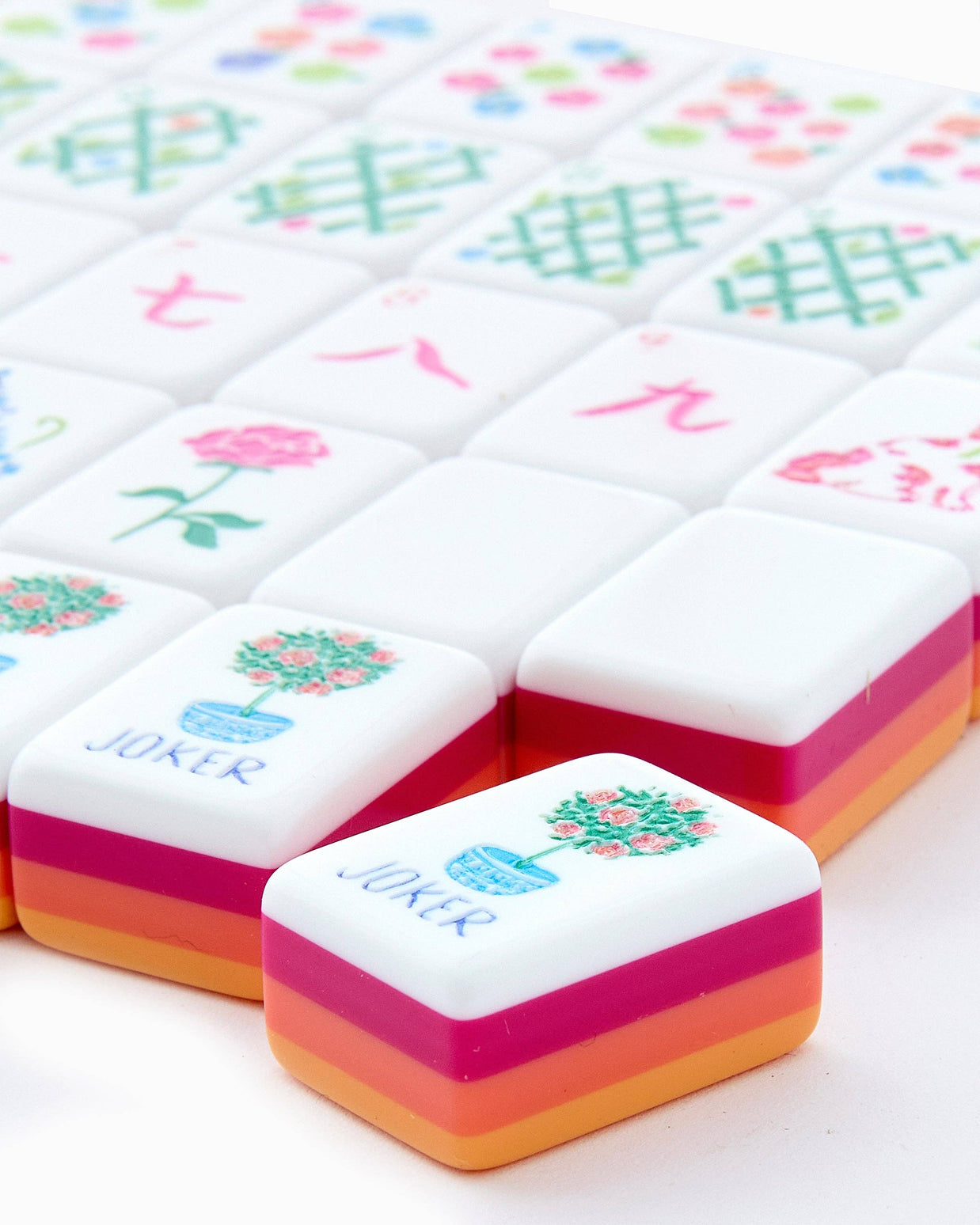 Mahjong tiles with colorful layered resin backs in coral, pink, and white featuring floral designs and Chinese characters