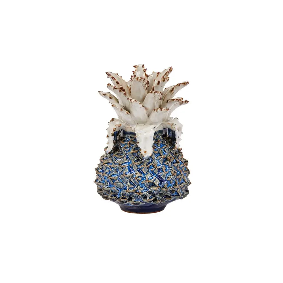 Ceramic pineapple-shaped vase with textured blue and gold body, cream-colored leaves with brown tips, decorative home accent