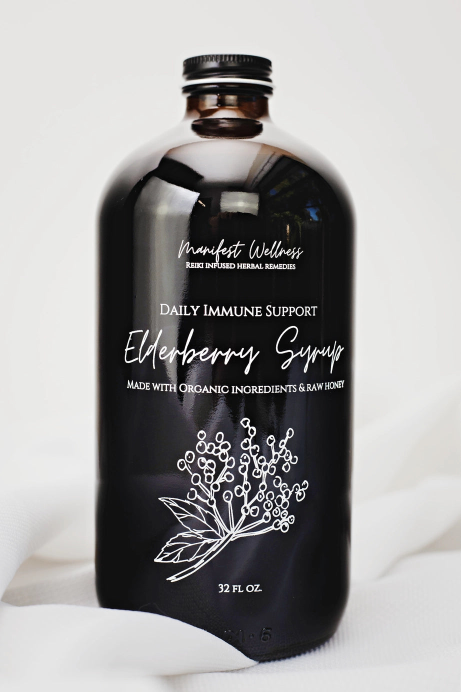 Black bottle of Elderberry Syrup with Manifest Wellness branding on a white background